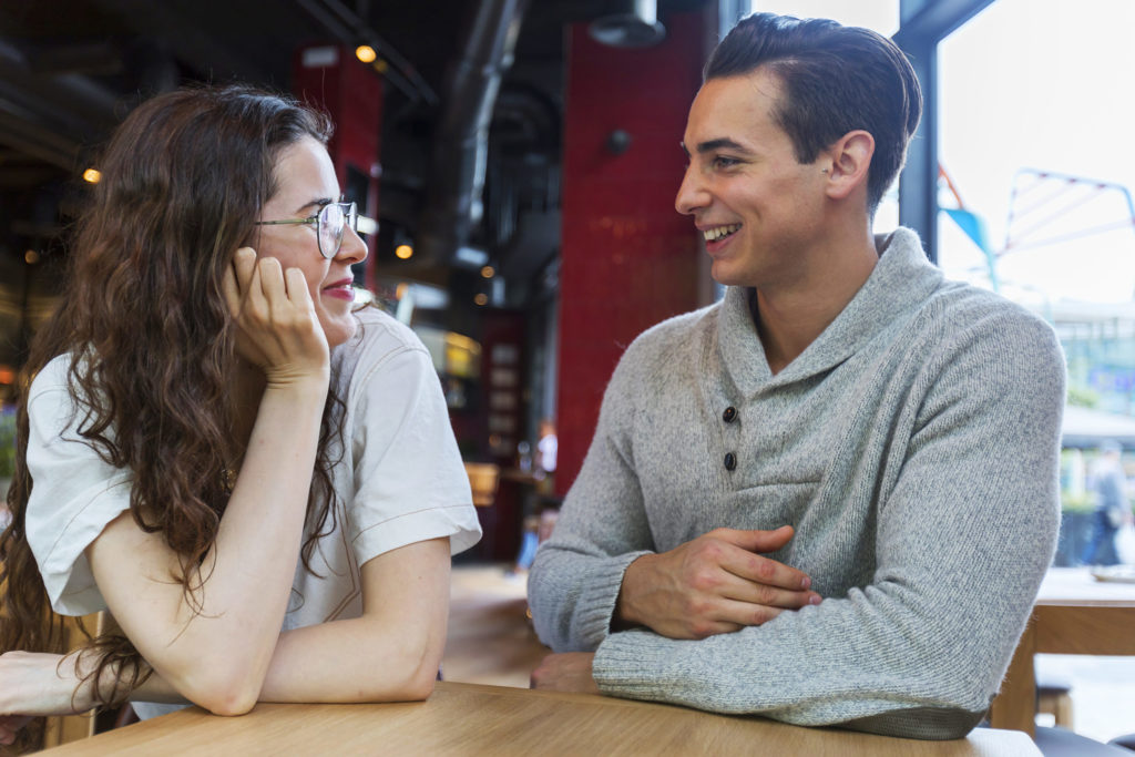 Couple sitting at table and talking in coffee shop